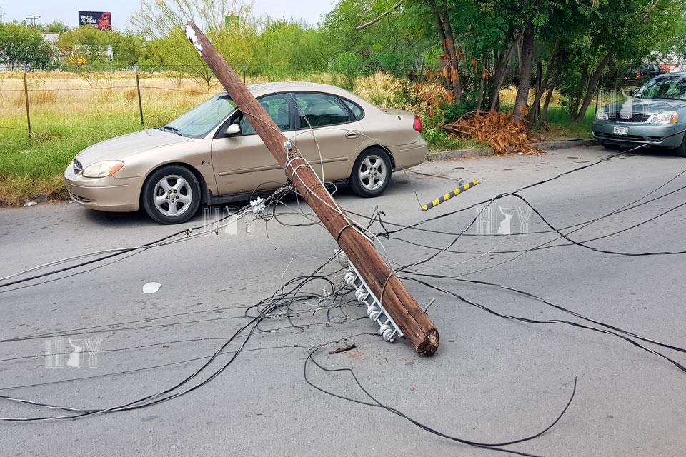 Hoy Tamaulipas - Cea poste de la CFE encima de carro en Nuevo Laredo